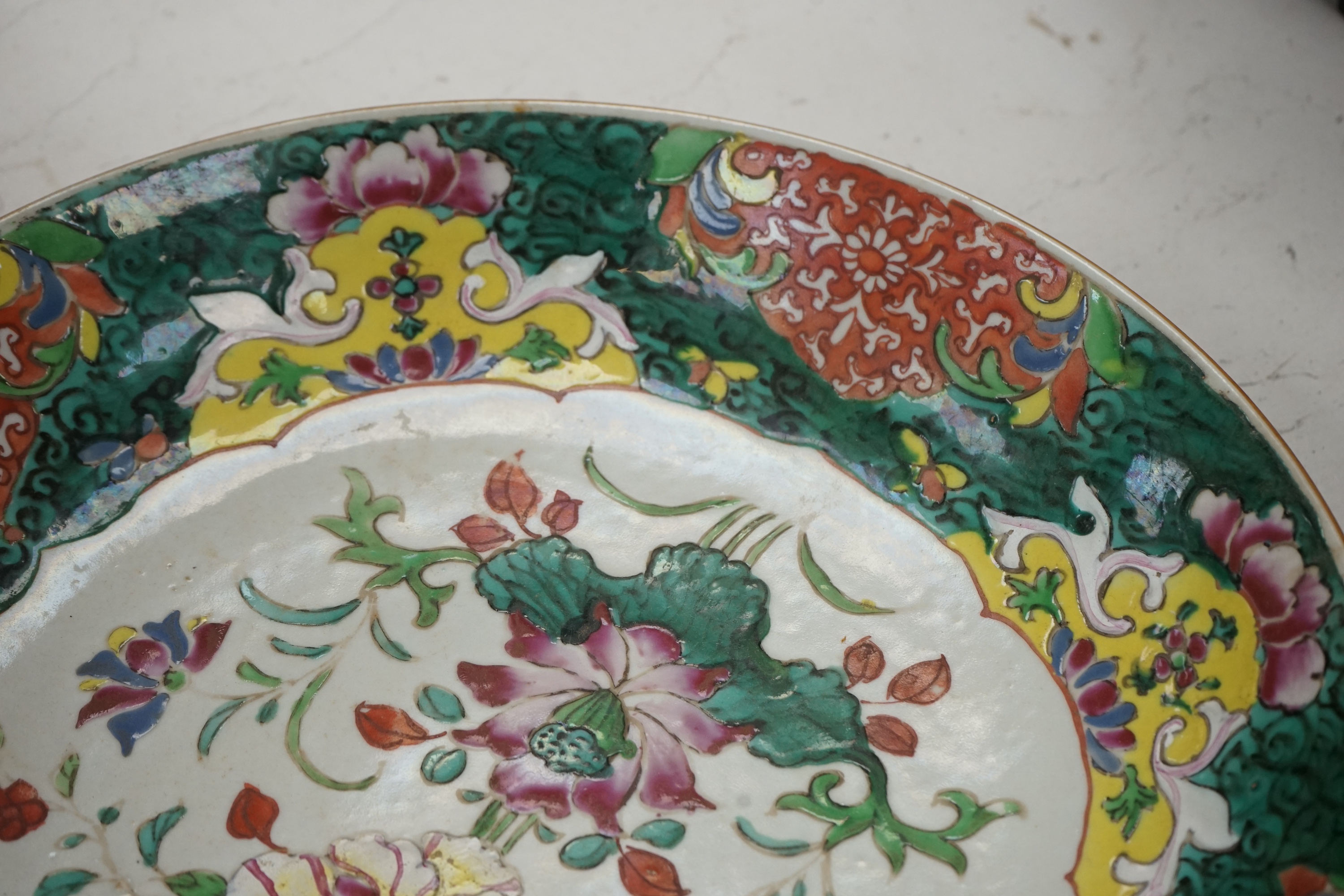 A Chinese straits famille rose dish, 19th century, 33cm diameter. Condition - crack to base